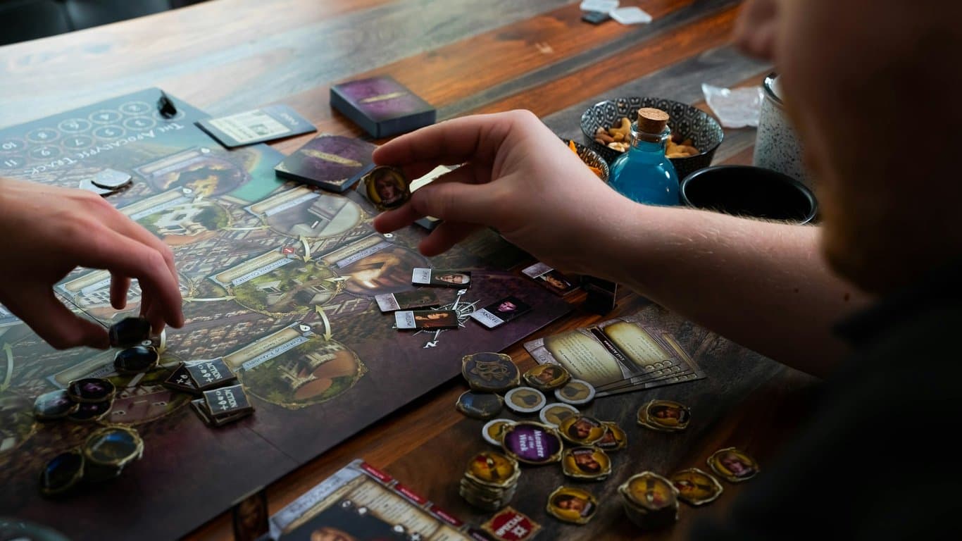 Twee volwassenen spelen laat op de avond een sfeervol bordspel aan een houten tafel