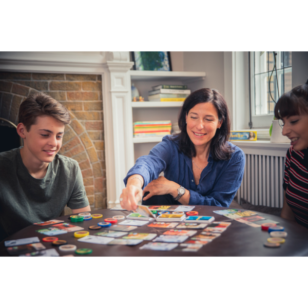 Gezellige avond met het gezin, mama speelt Splendor met kinderen